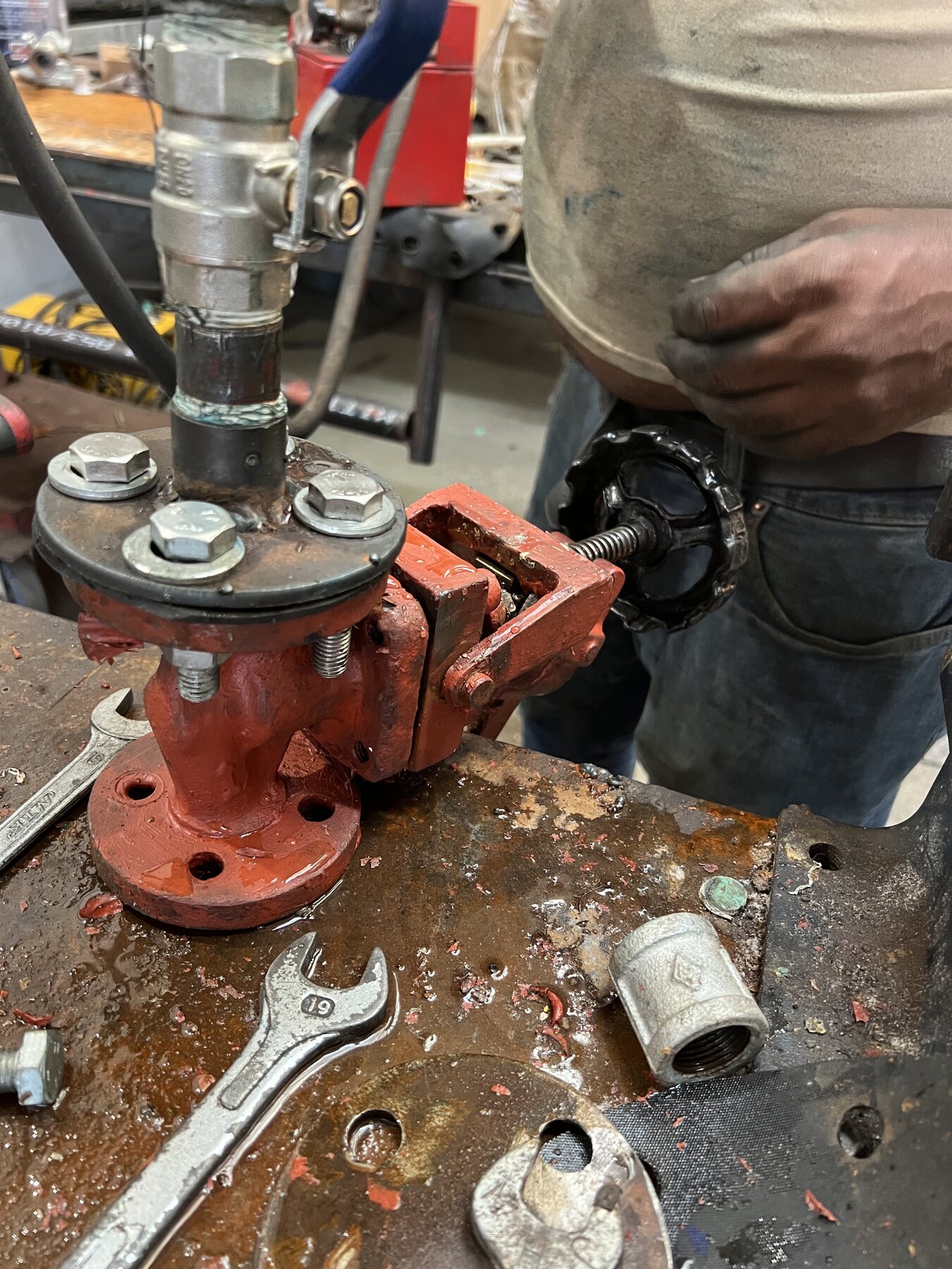 Technician operating a valve during the workshop pressure-test sequence